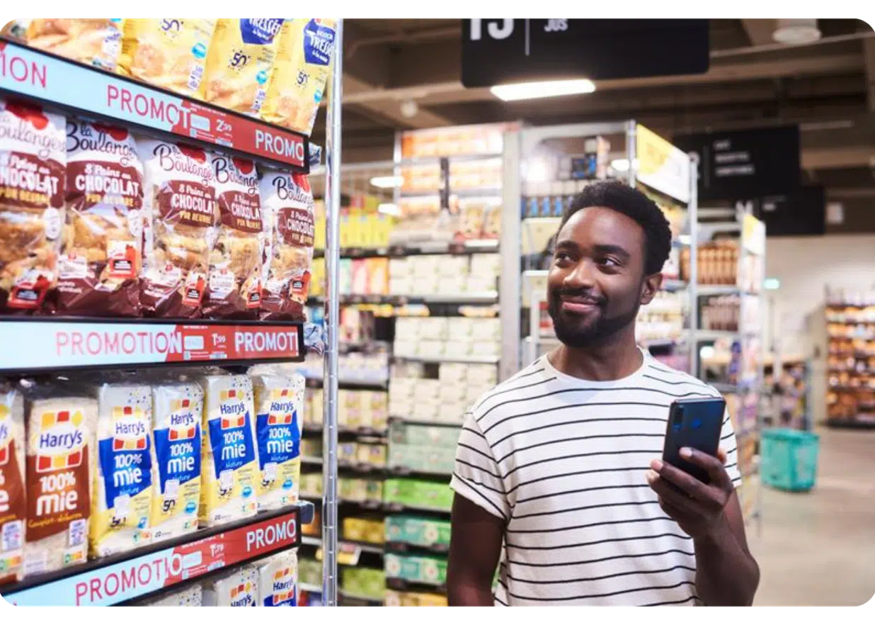 Man shopping in grocery store with phone